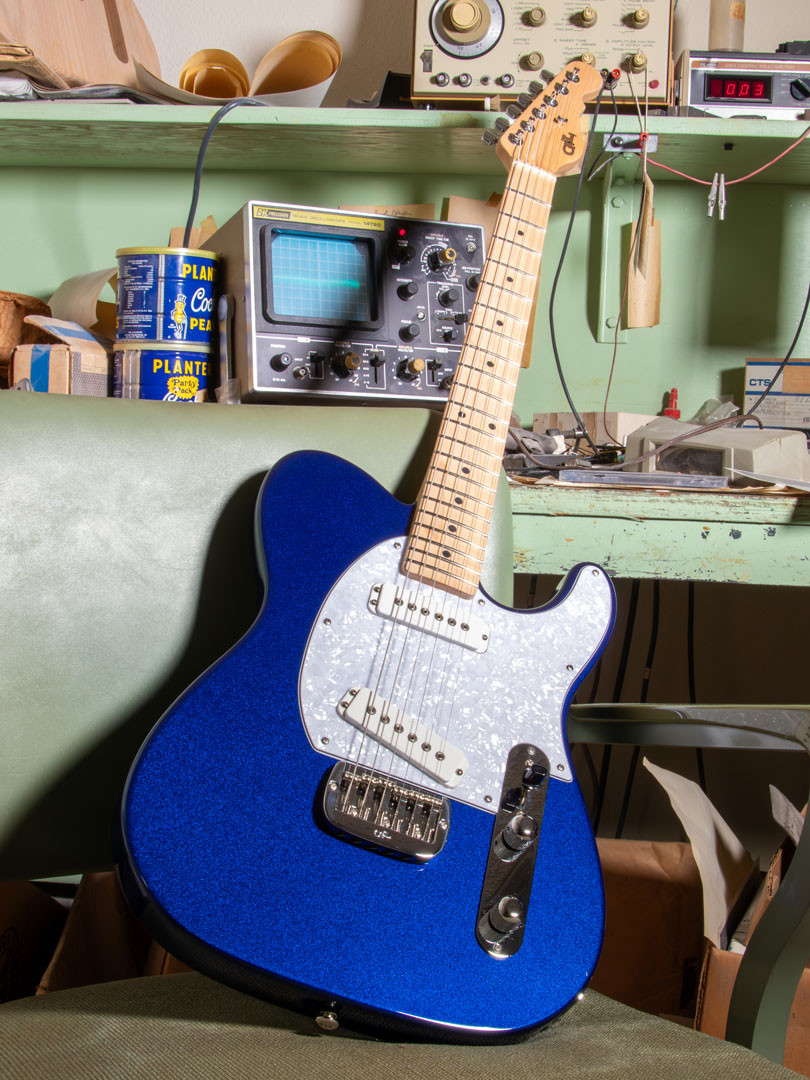 Hero image of a Blue G and L guitar resting against shelving in Leo Fender's work area
