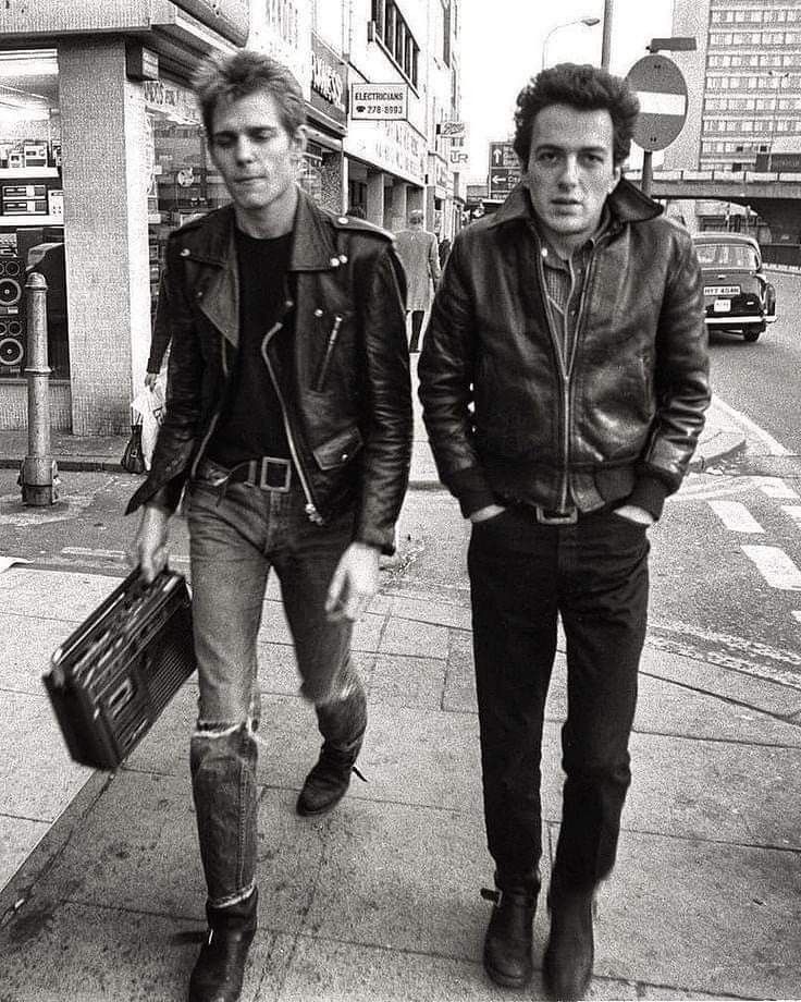 A black and white photograph of Paul and Joe walking down the street in their full Punk/Rockabilly attire, which includes combat boots.