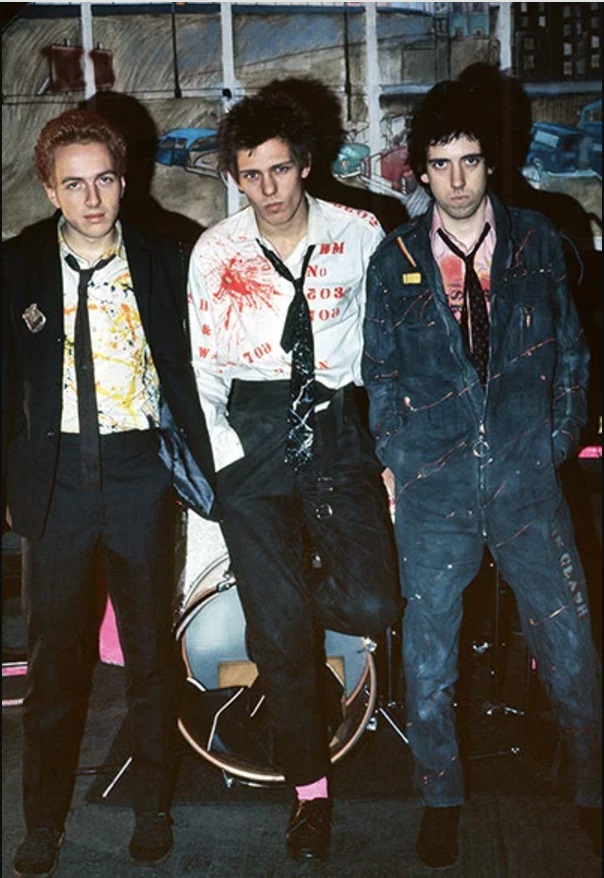 The Clash in their paint-splattered & hand-stenciled attire, 1976. Photo by Sheila Rock.