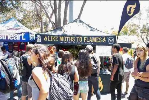 young and alternatively dressed boys and girls wait at a merch tent to see the band