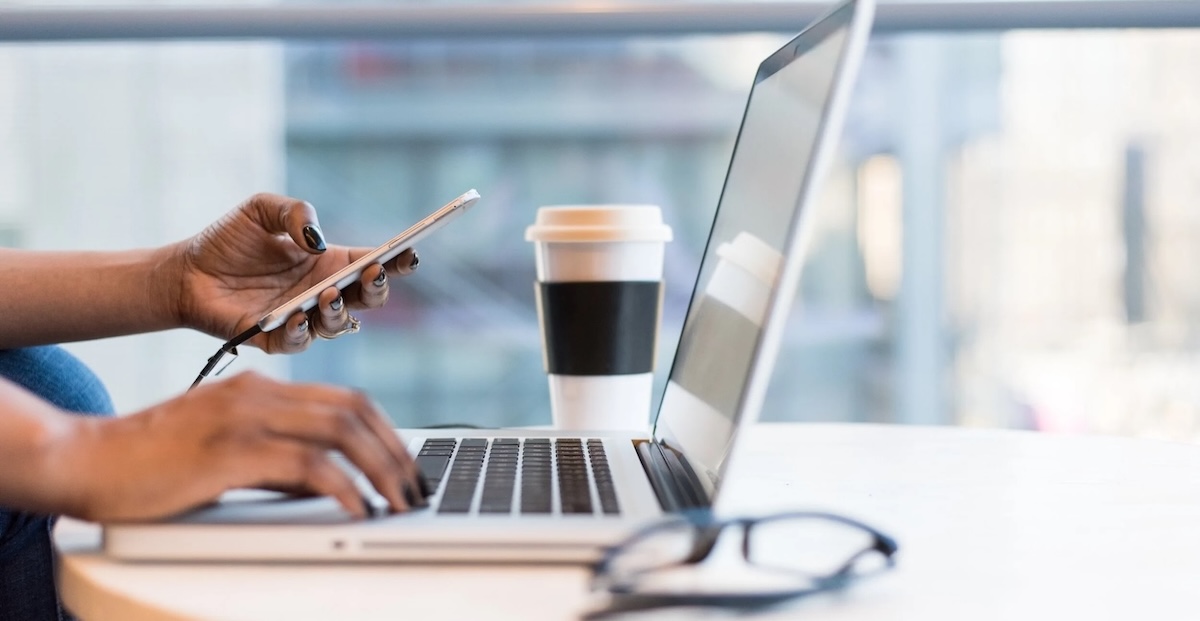 photo of person typing on computer and phone