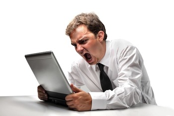 a photo of a man who is angry and yelling at his computer screen