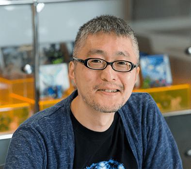 An image of Ken Sugimori, the first illustrator for Pokemon. Sugimori is looking into the camera with a pleased smile.