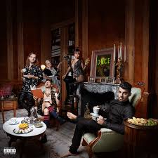 Album cover set in an ornate living room where several stylishly dressed people lounge and pose, including a man in black reclining on a green chair in the foreground with food and tea laid out on a table.