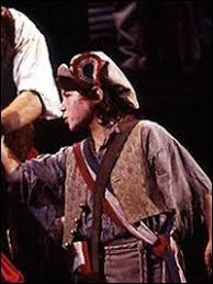 Young boy in a costume on stage during a performance.