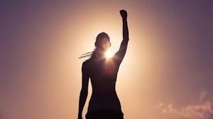 woman standing in a silhouette with sunlight coming from behind her