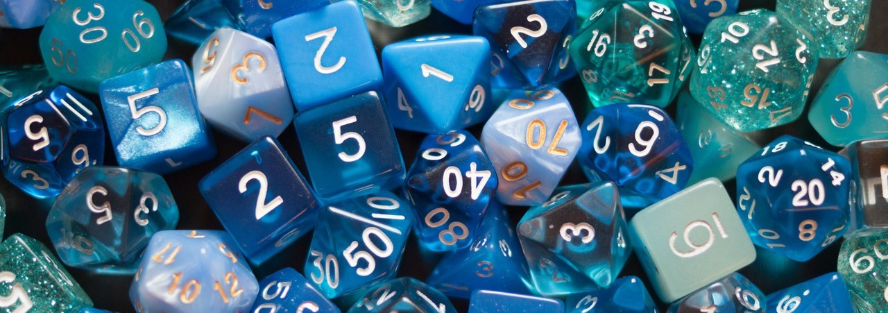 A pile of dice all different shades of blue. These dice include d4s, d6s, d8s, d10s, d12s, and d20s.