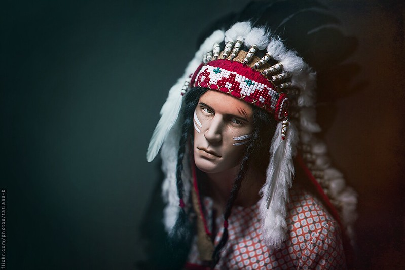 photo of a native american wearing facepaint and headdress