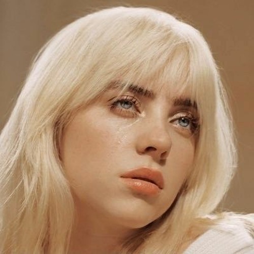 An image of Billie Eilish with blonde hair. She's looking away from the camera longingly. A tear is falling from her cheek