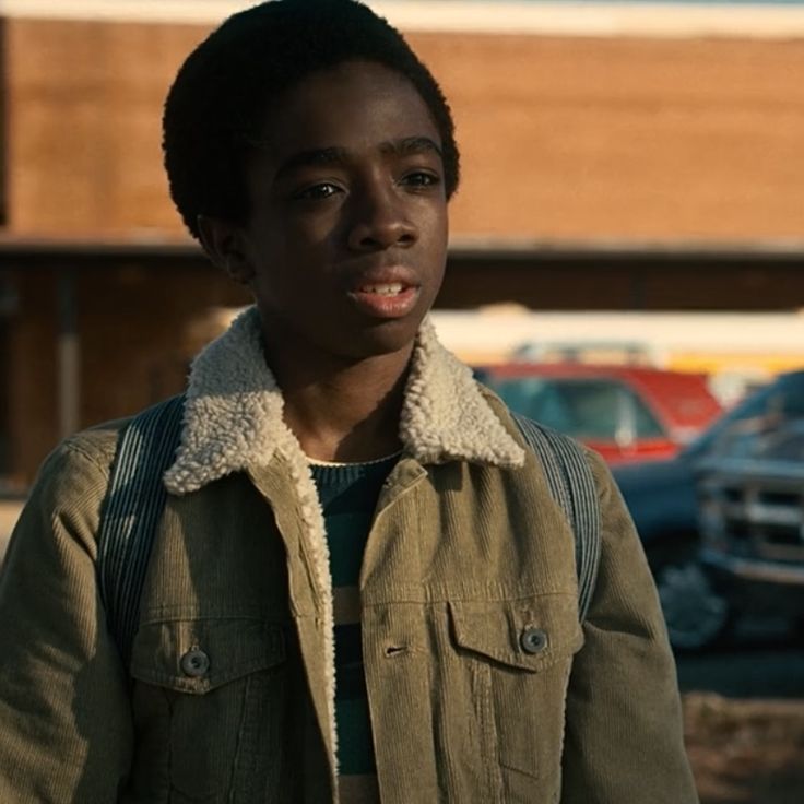 A young boy with short black hair looks warily at someone.