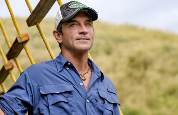 Jeff Probst standing on a boat looking off into the distance.