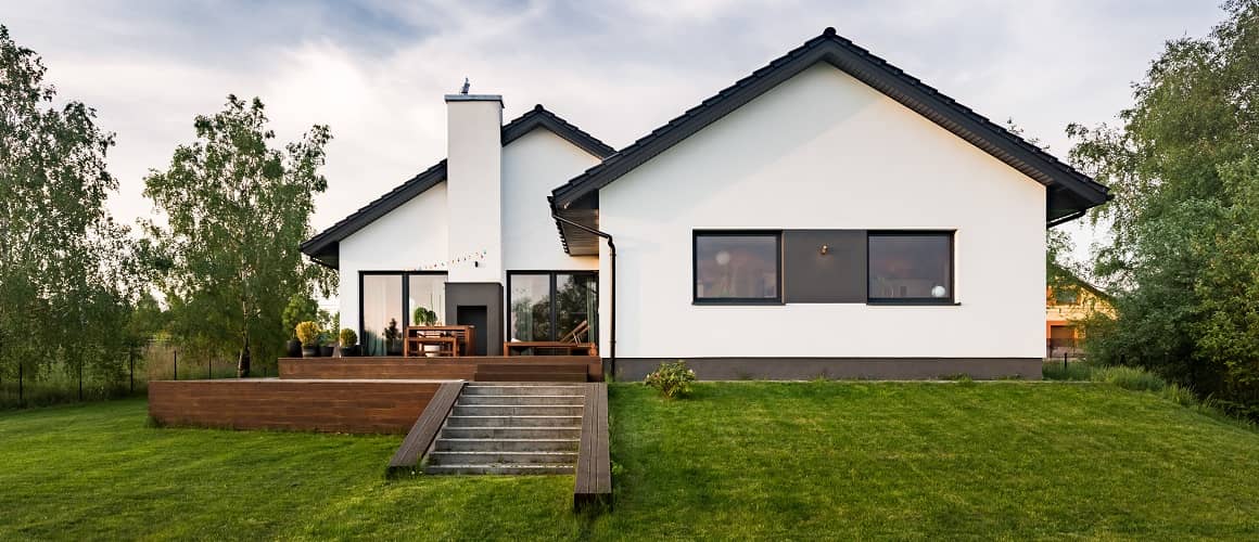 A typical single family home. White with black trim and a natural wood patio.