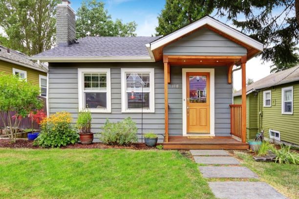 An average single family home. Painted grey with natural wood door and trim.