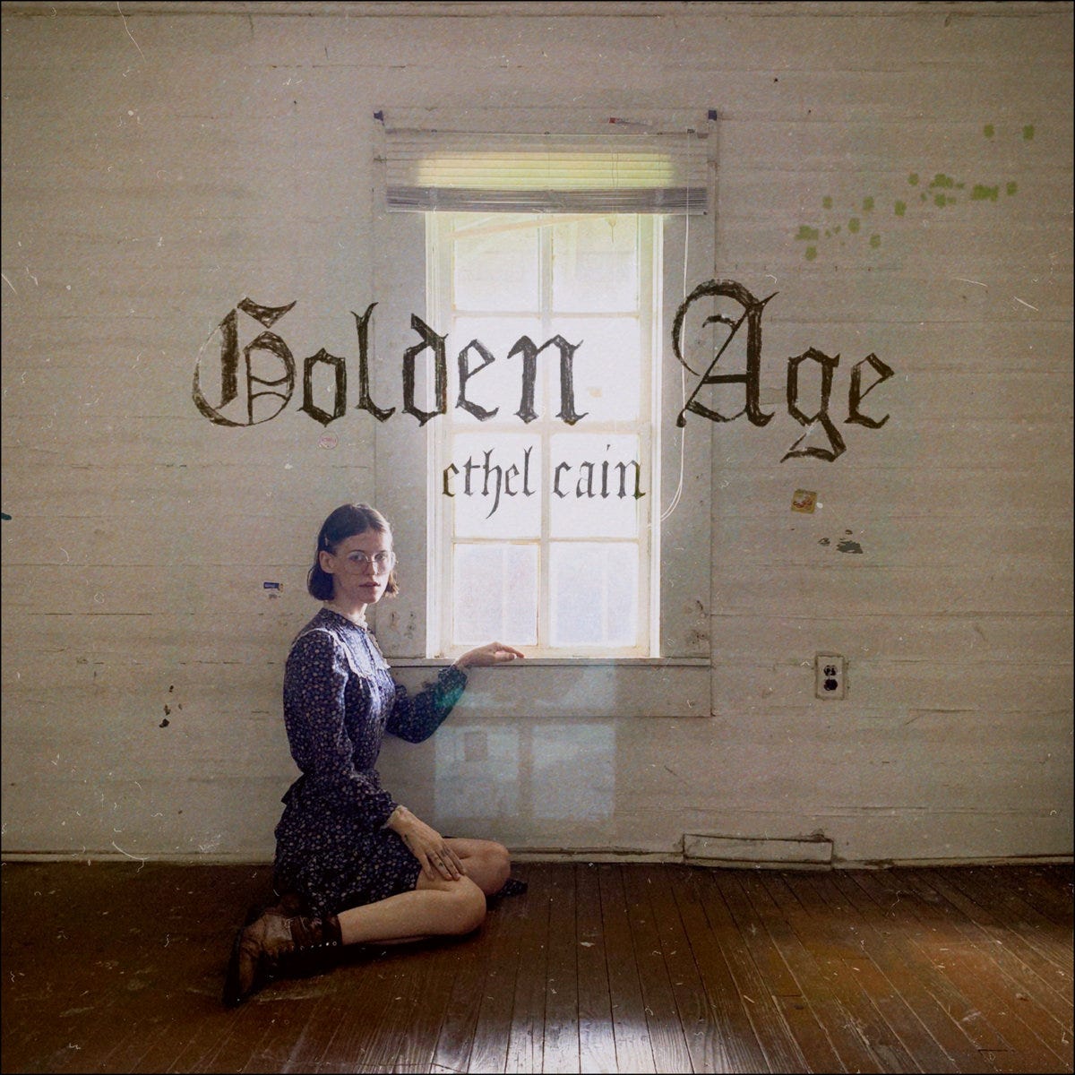 cover art for EP Golden Age, a woman sits on the brown plank ground with her hand resting on a window sill