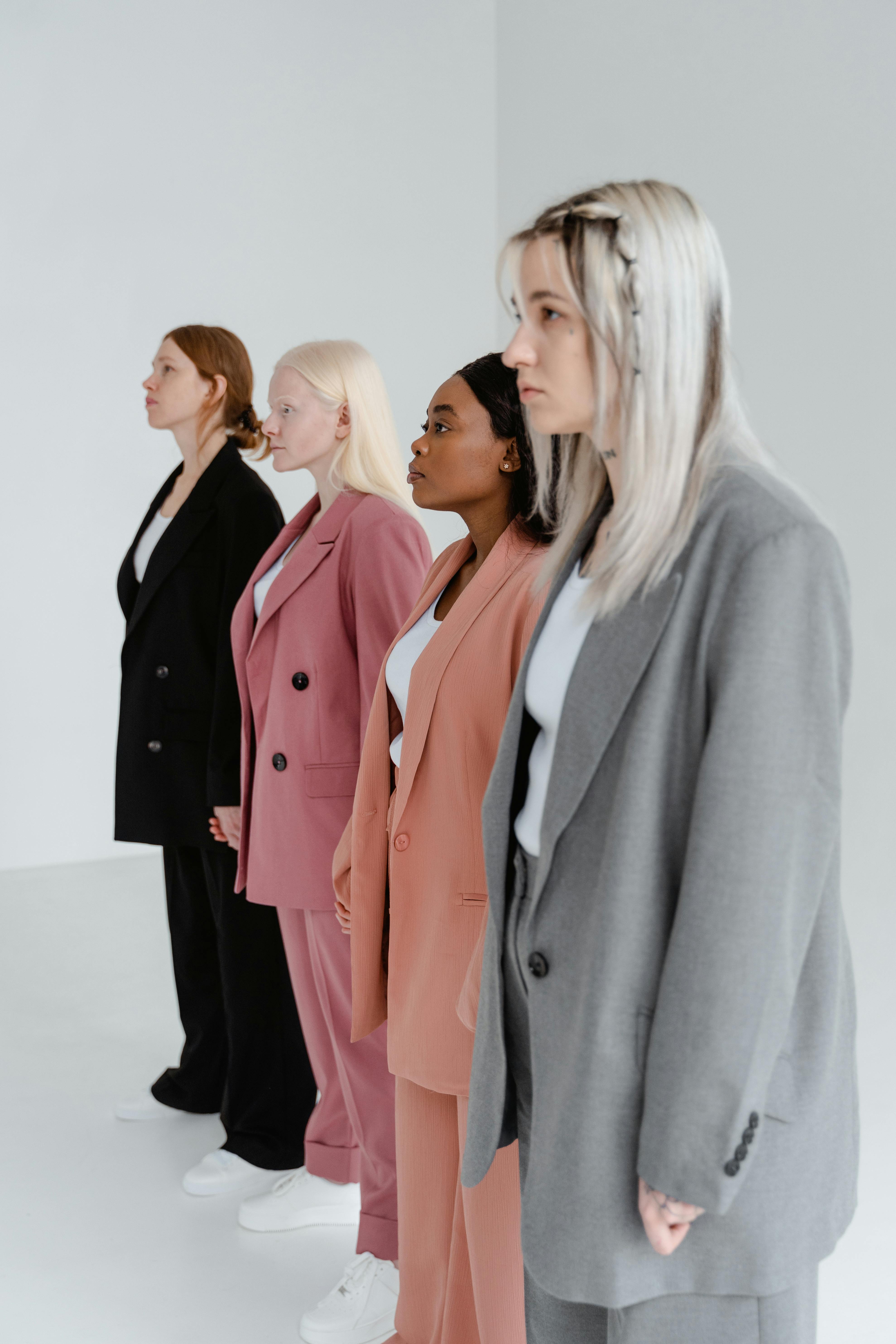 Women Wearing Blazer and Pants in Different Colors Standing Together