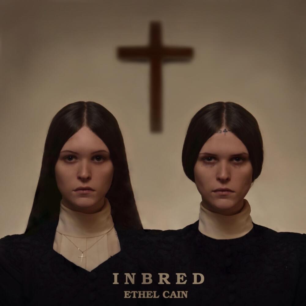 cover art for EP Inbred, Two almost identical women stand side by side in priest like dresses with a cross unfocused in the background