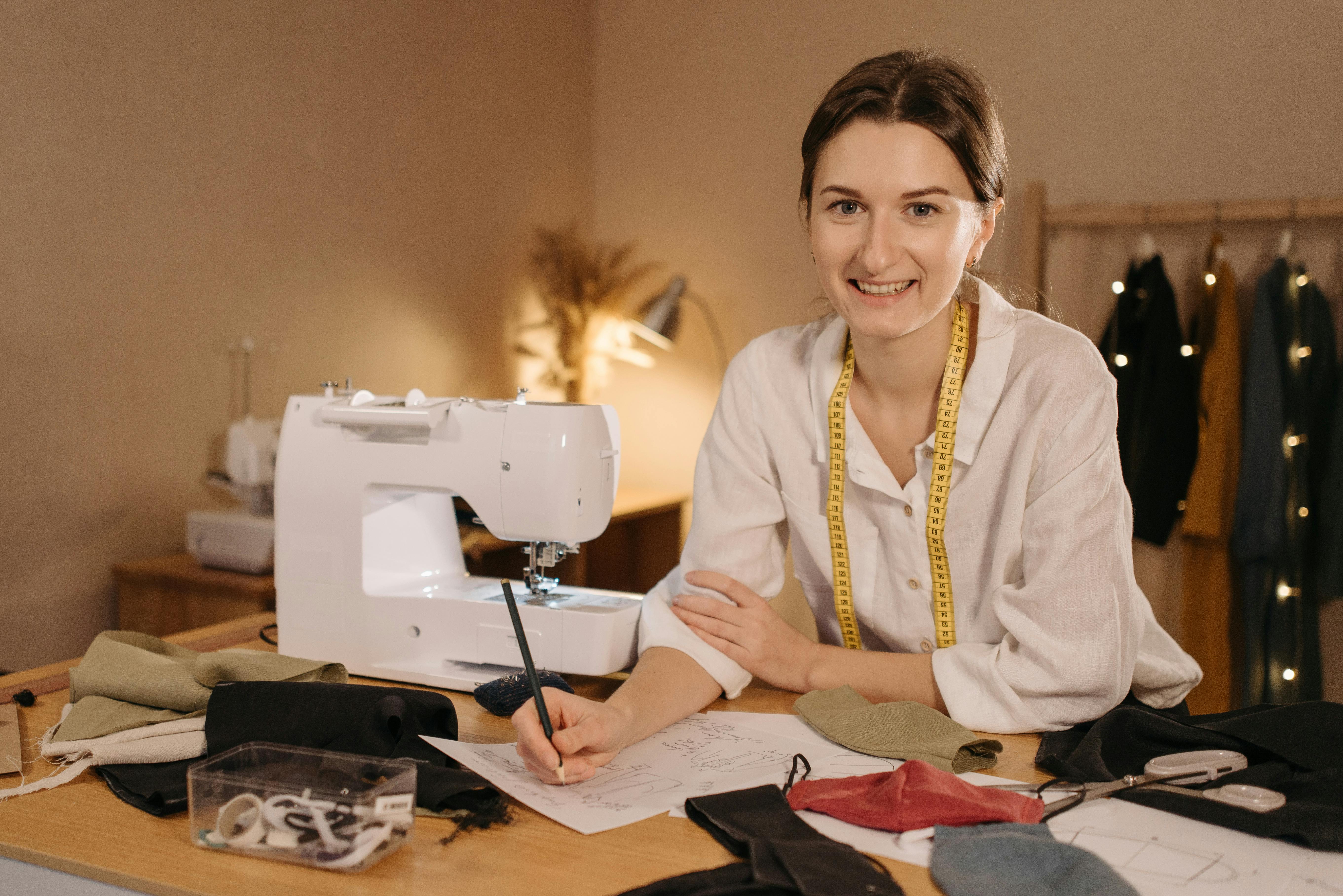 A Woman in White Long Sleeves Smiling in front of sewing machine
