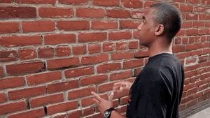 A man speaking to a brick wall