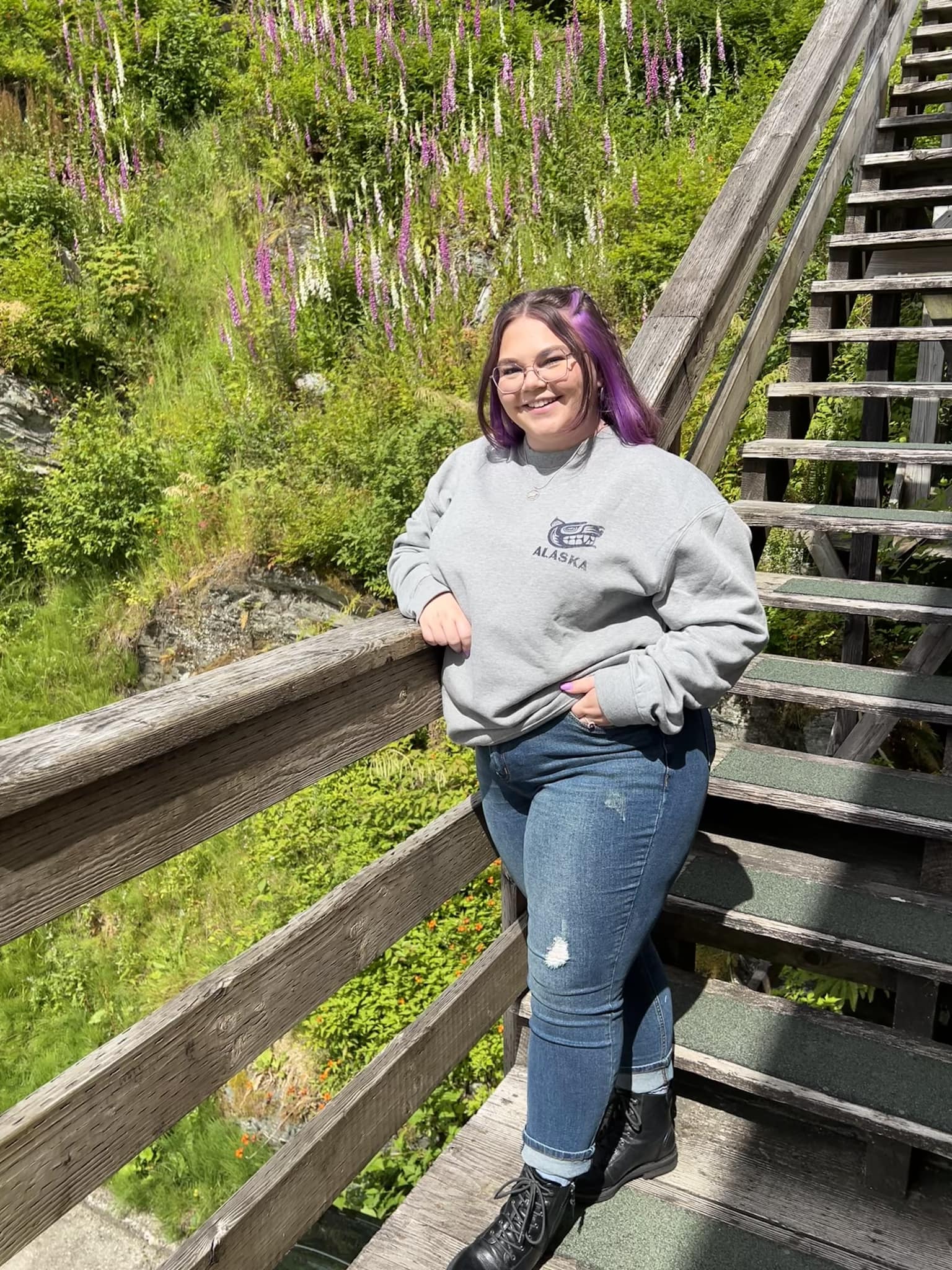 Chrystie Middleton leaning againt the railing of some outdoor wooden stairs in Ketchican, Alaska