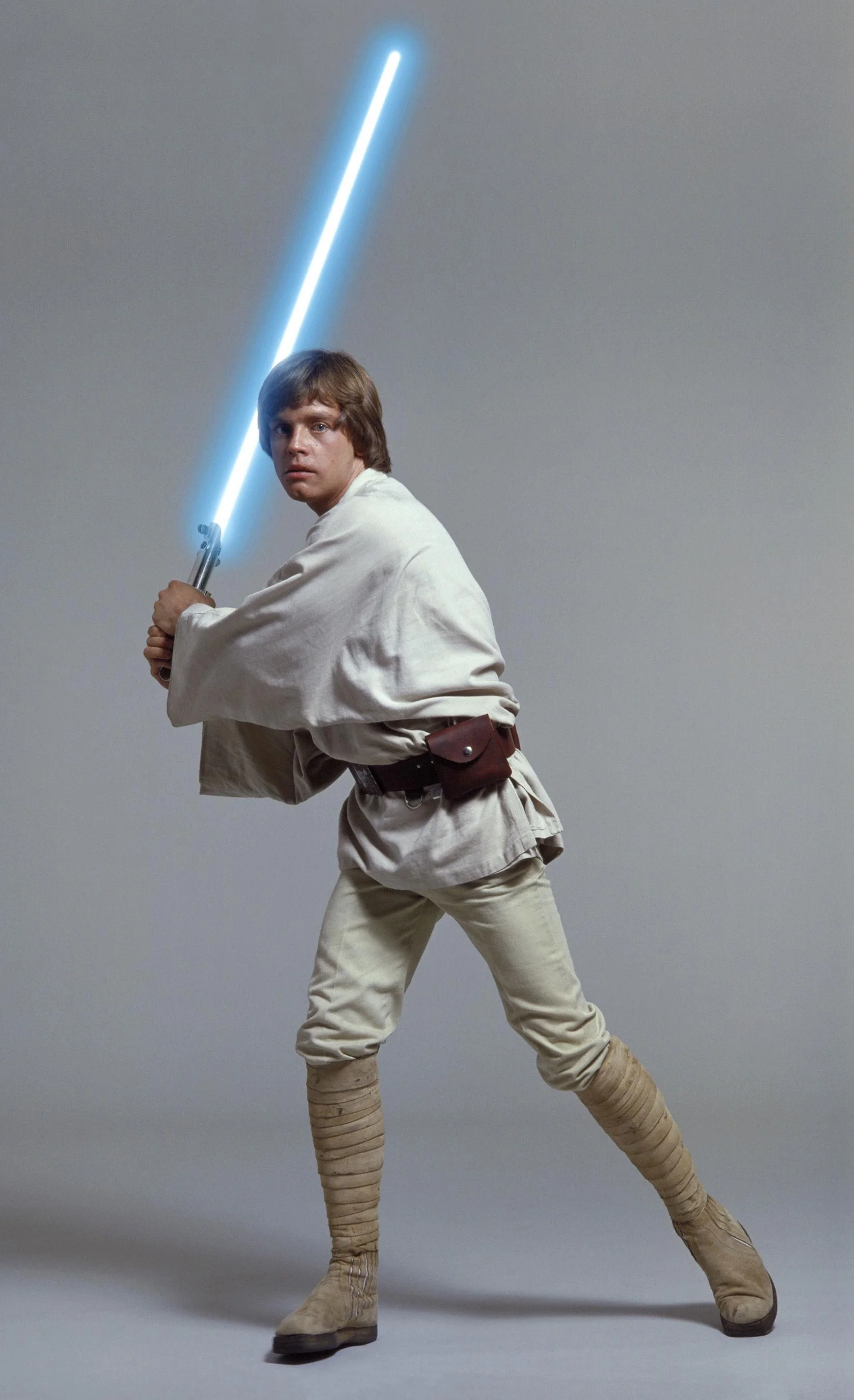 a photo of Luke Skywalker in his Episode 4 garb with a blue lightsaber in hand, behind his head like a bat.