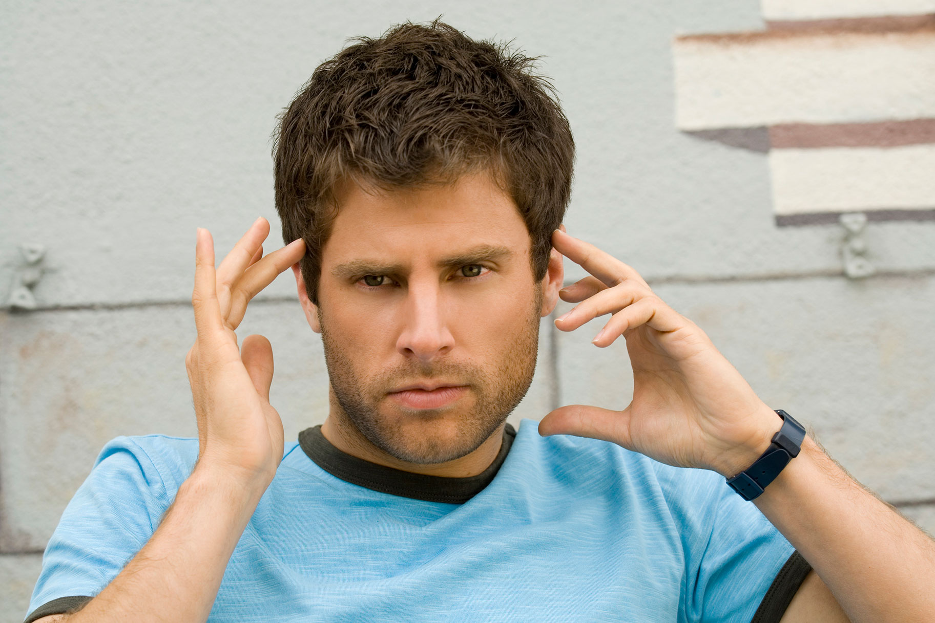 a photo of Shawn Spencer with his fingers to his temples as he stares intently at something unseen behind the camera.