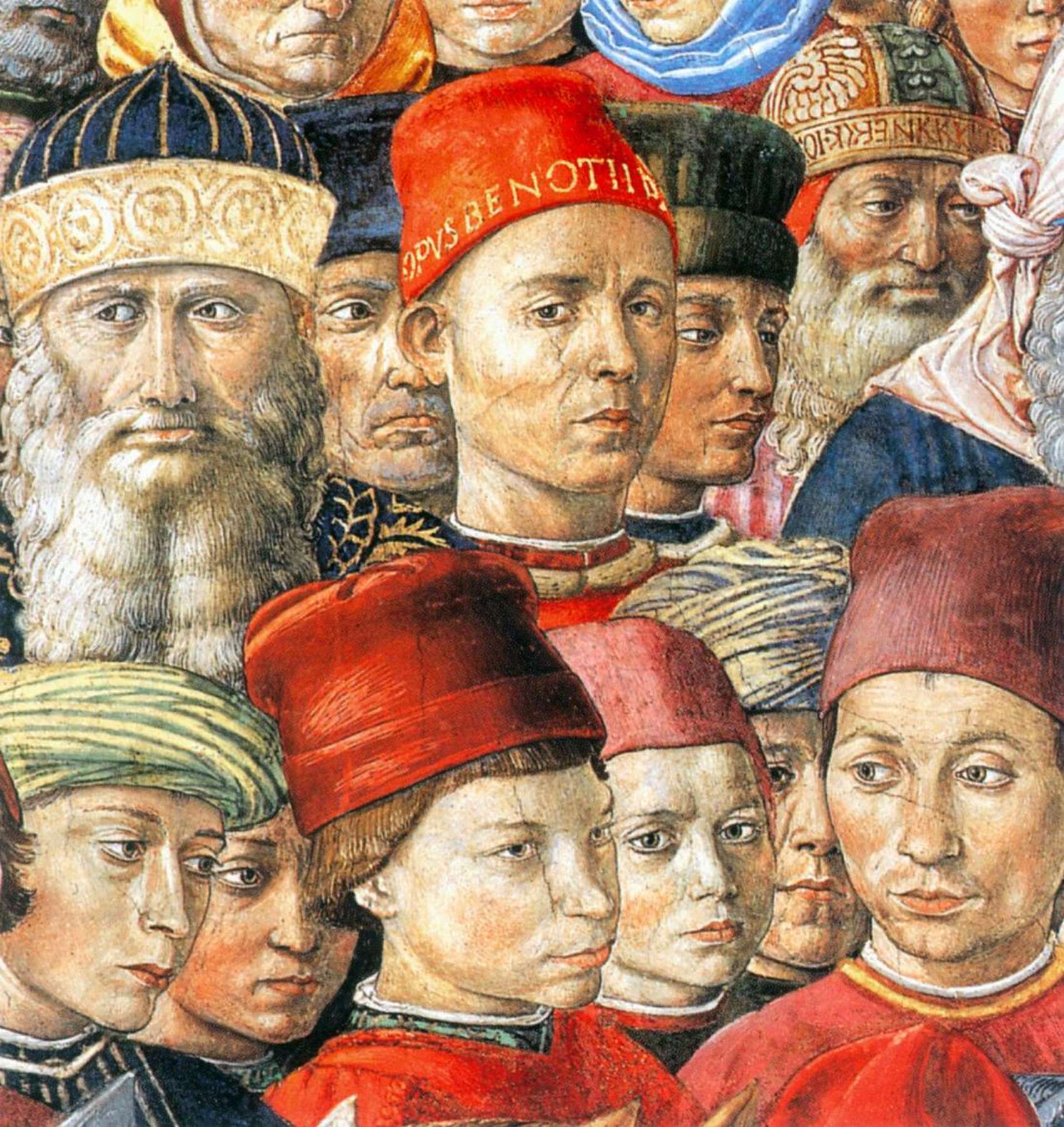 A painting depicts a large crowd of men. Their faces overwhelm the painting so no background can be seen. They are all dressed in tudor-style clothing. None of the men are looking at the viewer of the painting or each other except one, who is in the center of the crowd and wearing red. He looks out from the painting with a somber frown on his face.