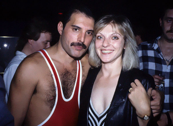 a picture of Freddie Mercury with Mary Austin who is a blonde woman smiling