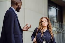 An image of a professional looking woman looking at a man disgusted and offended because of something he said.