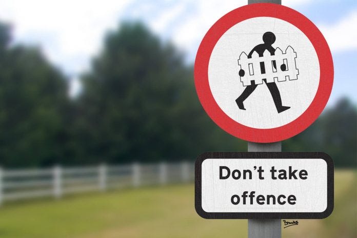 A roadside signpost with a figure walking while carrying a picket fence with the words don't take offence underneath.