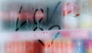 an image of the word love and a heart below it drawn in the condensation of a cooler that contains soda