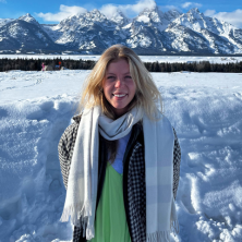 photo of Megan smiling with the snowy grand teton mountains in the background