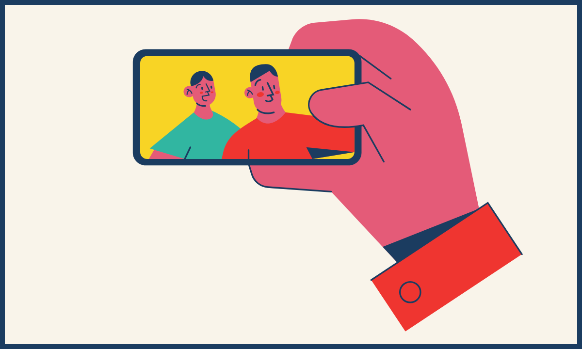 a hand holding up a cell phone with two people in frame for a selfie