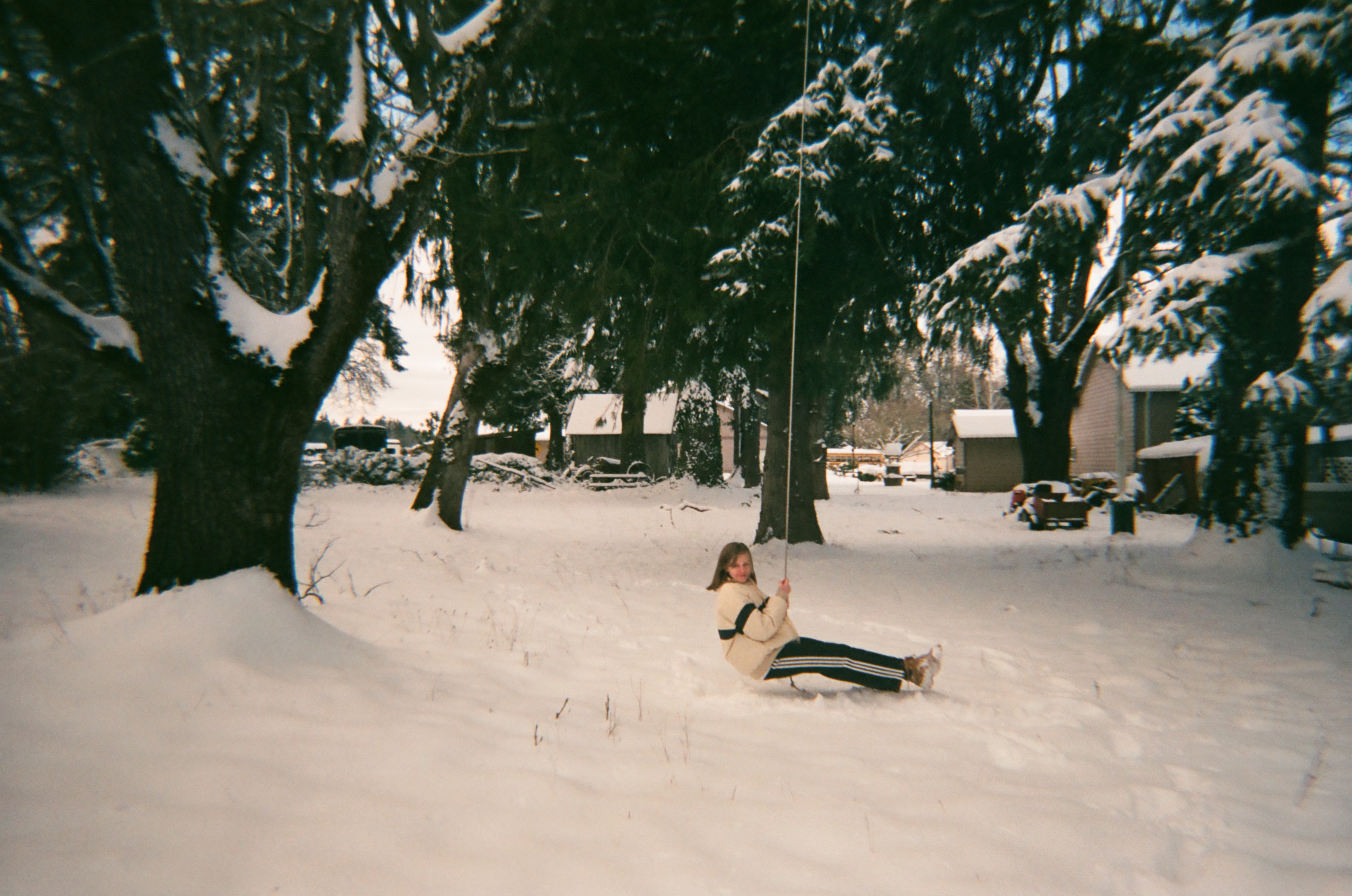 Girl on a rope swing in the snow, western Oregon country.