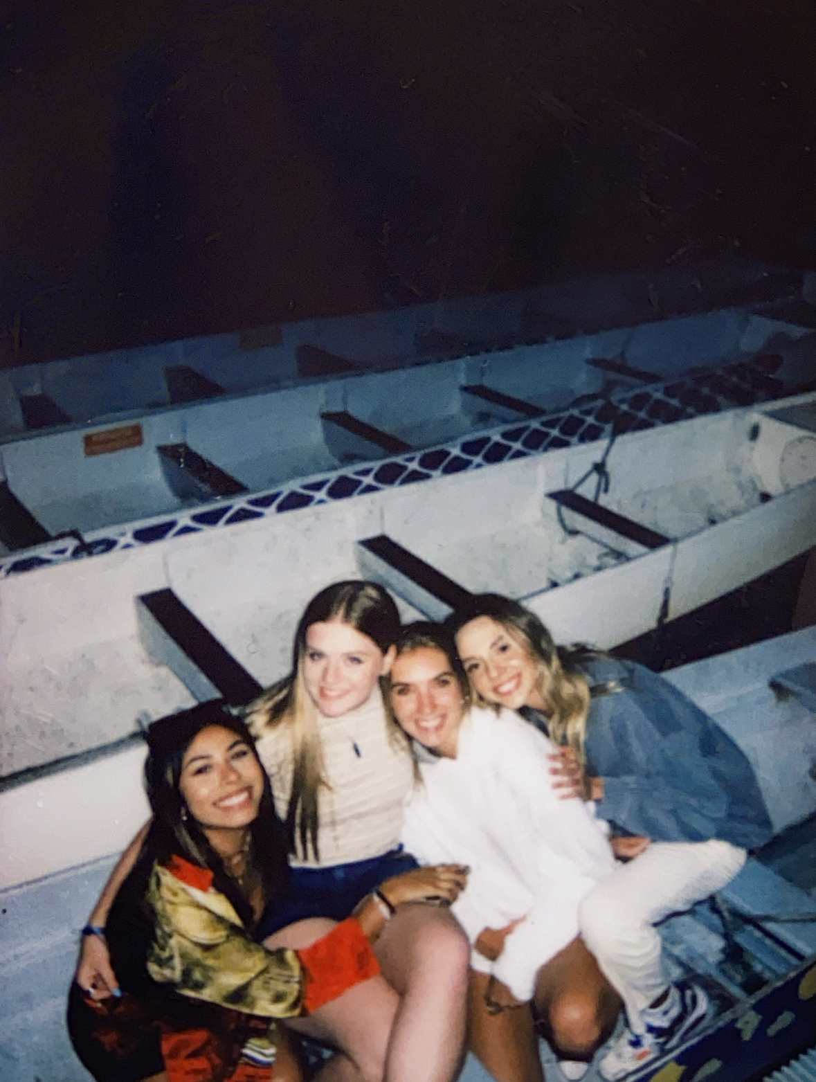 Four young women sitting in a dragon boat racing boat in downtown Portland, Oregon waterfront.