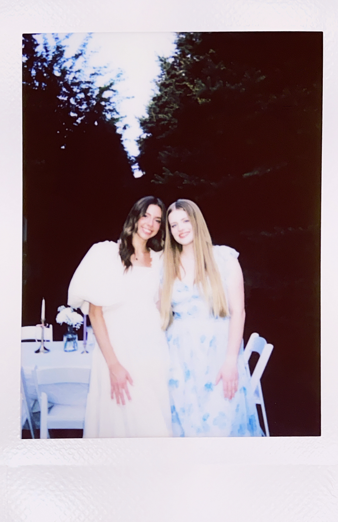 Polaroid of two young women in dresses.