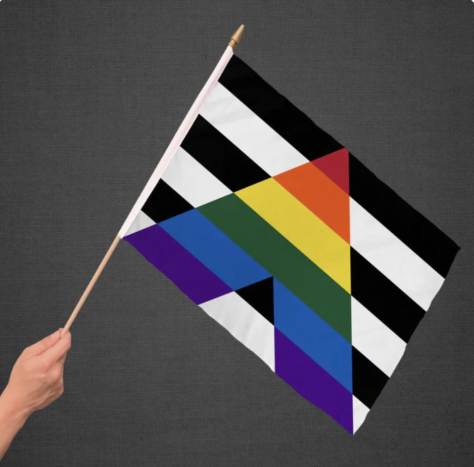 A hand holding a gay/straight alliance flag.