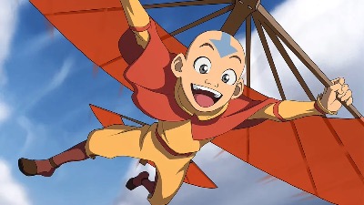 Avatar Aang looking jovial as he flies through the sky using his glider