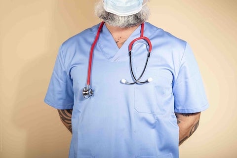 closeup angle of a man in scrubs wearing a medical mask