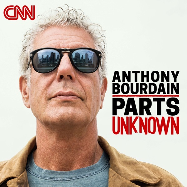 An older, white haired Bourdain wears sunglasses and looks at the camera. In the reflection of the glasses, the New York skyline is reflected. His name and the name of the show are featured to the right of his face.